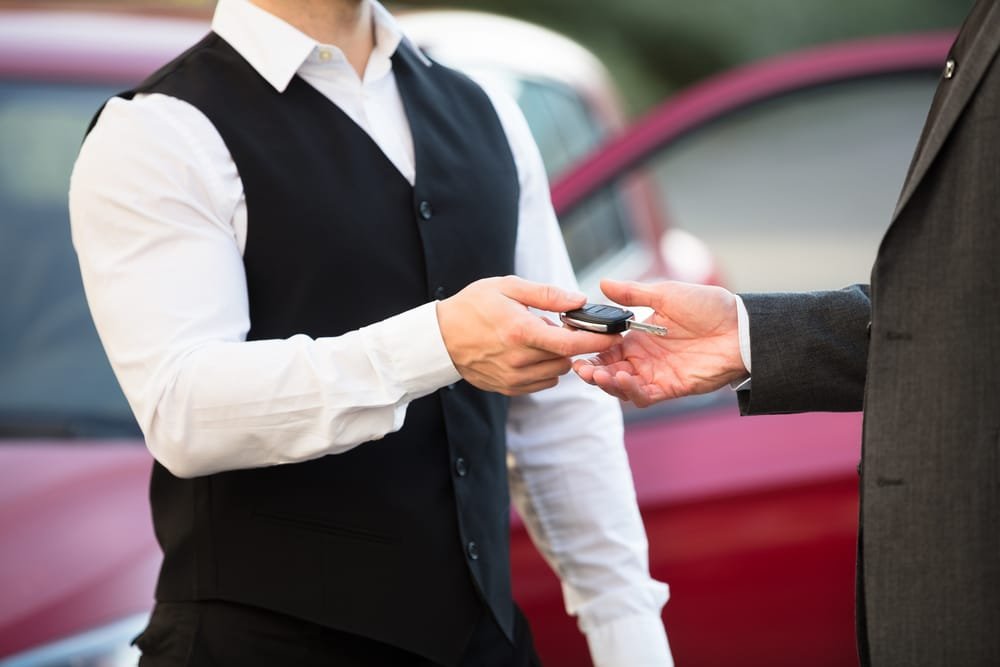 Close up,Of,Valet's,Hand,Giving,Car,Key,To,Businessperson